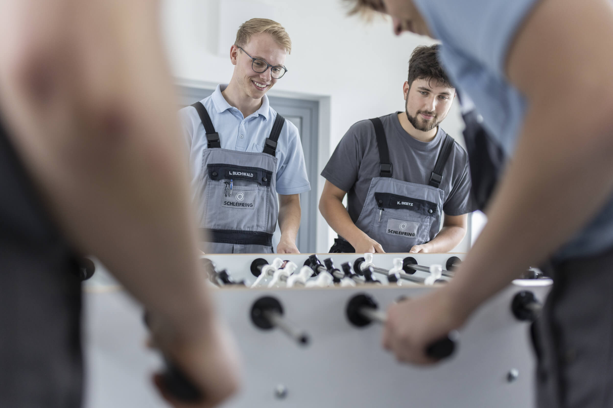 Trainees play table football together during their break and are clearly having fun.