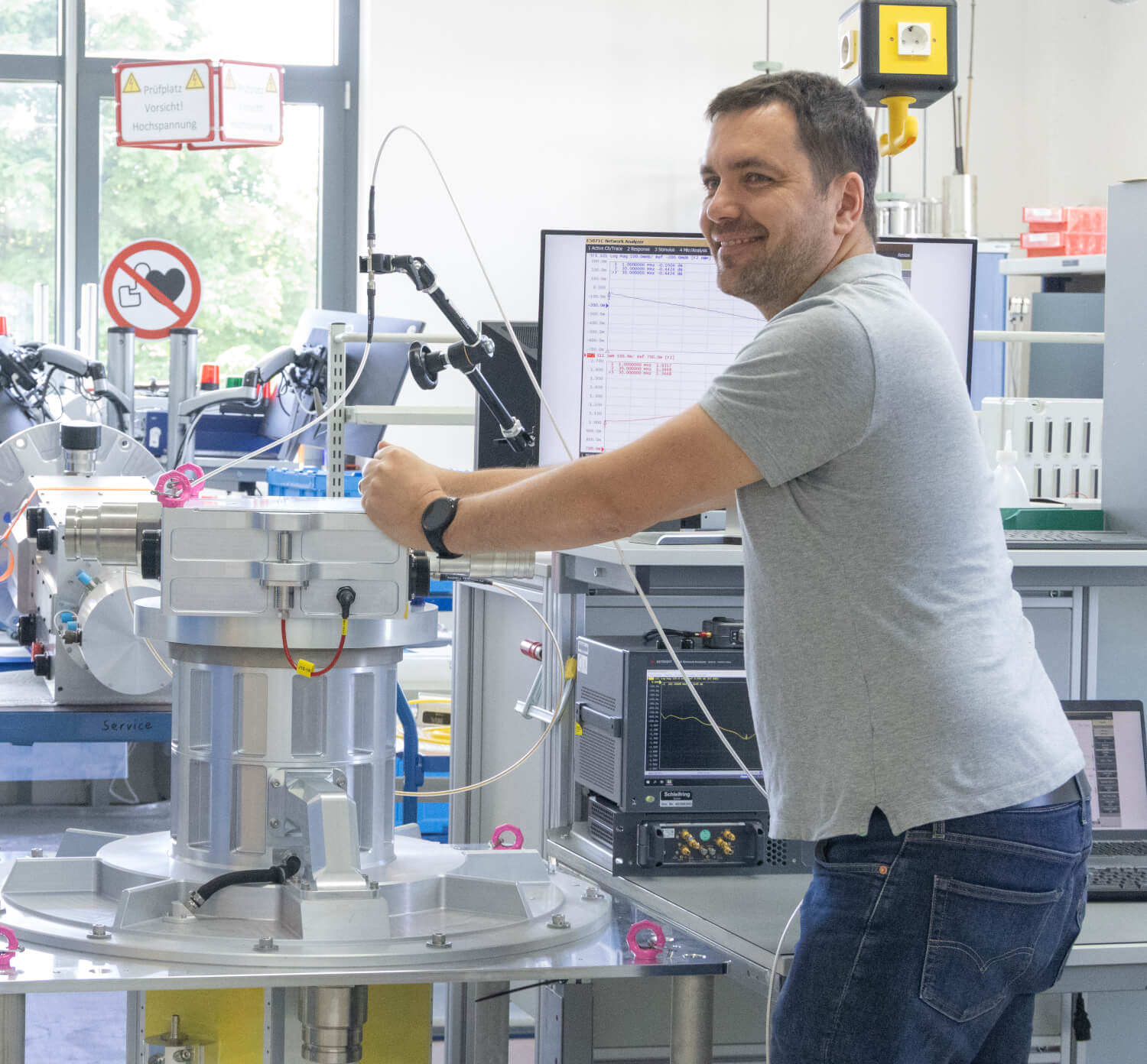 Production employees at Schleifring Fürstenfeld work on a test bench with modern measuring technology.