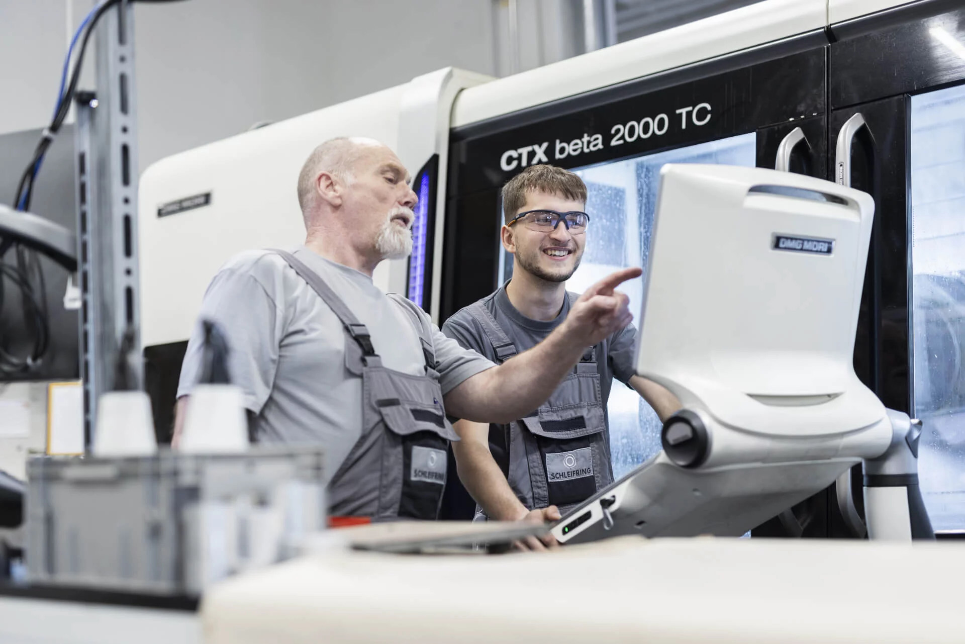 Trainer explains to the trainee the operation of a CNC machine of the type CTX beta 2000 TC.
