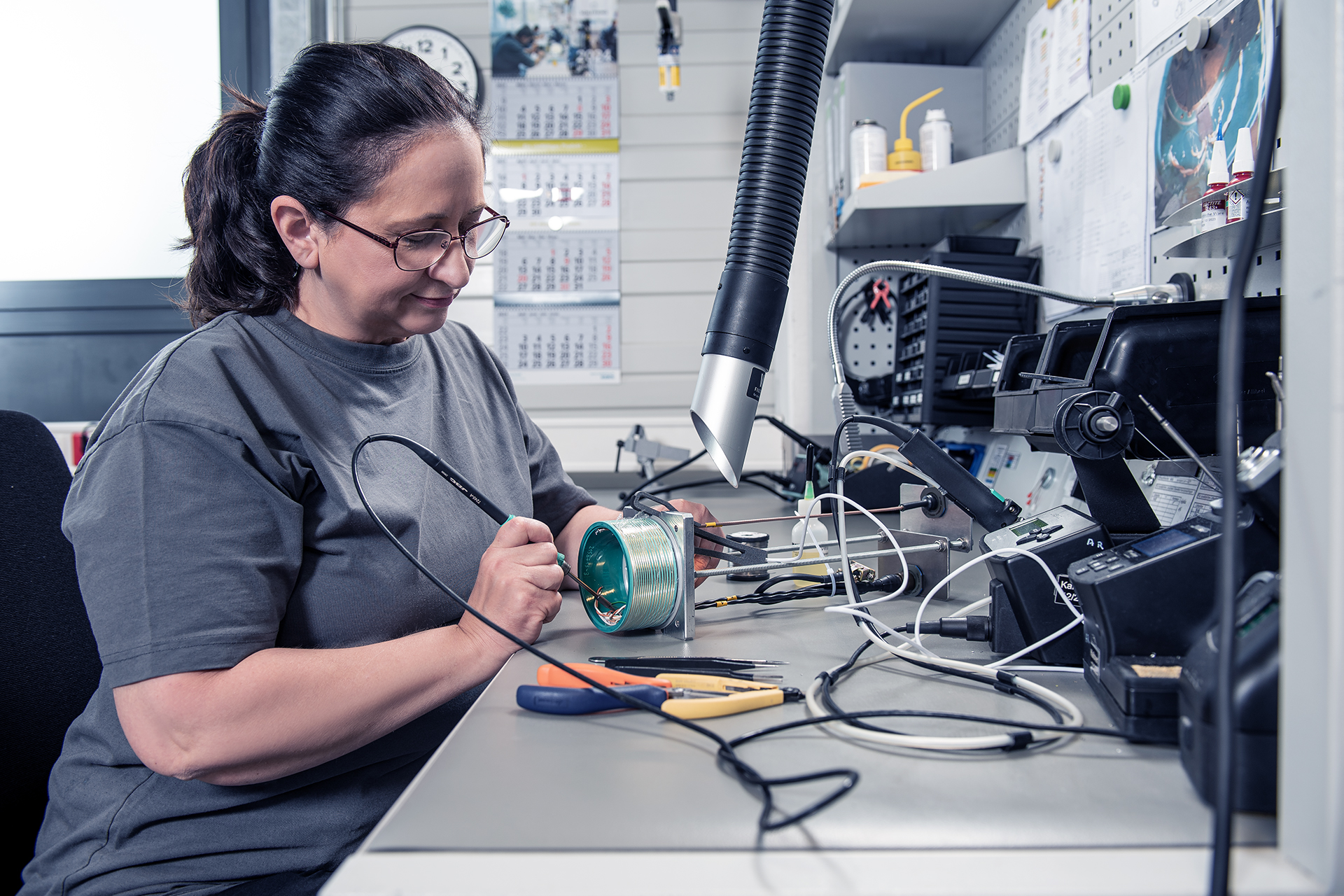SCHLEIFRING employee performing a mechanical inspection of an electronic component.