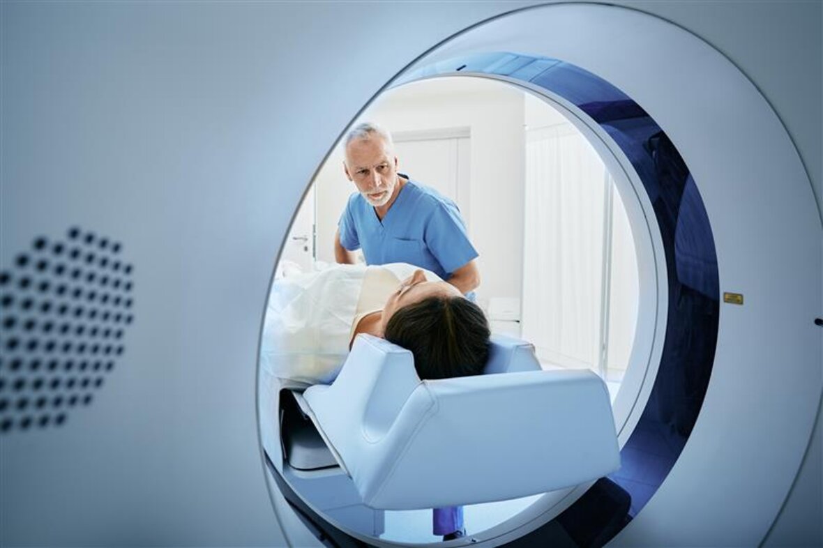 A patient is prepared for a CT scan, assisted by medical professionals – modern imaging with contactless data transmission.