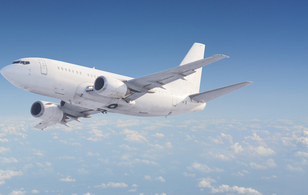 A passenger plane flies high above the clouds.