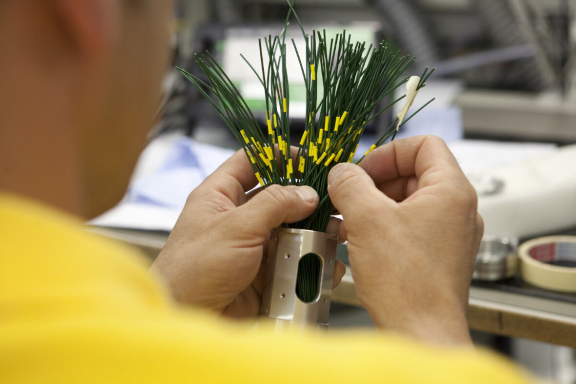 Precision mechanical repair of slip ring cables in the workshop.