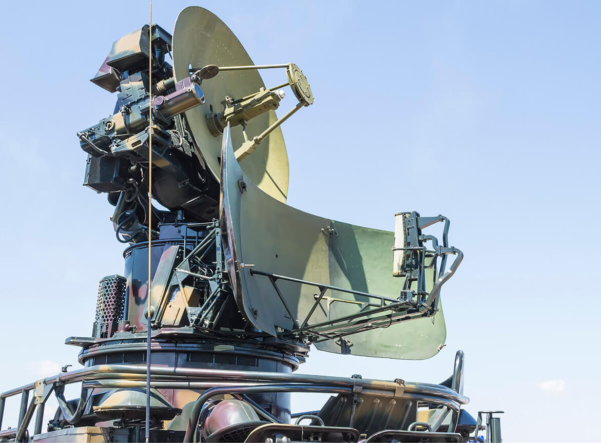 Military radar with several large antennas against a blue sky.